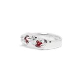 Silver ring with red gemstones on a white background