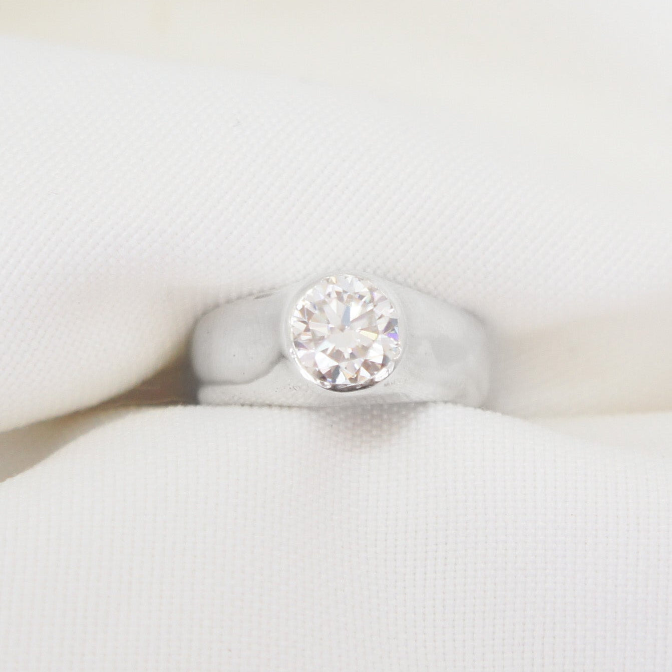 Silver ring with a diamond on a white background