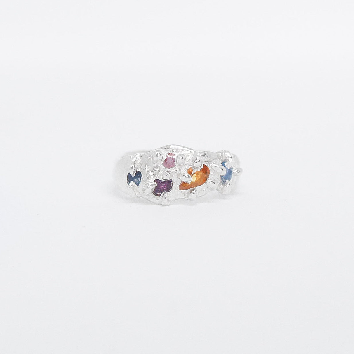 Ring with colourful sapphire on a white background