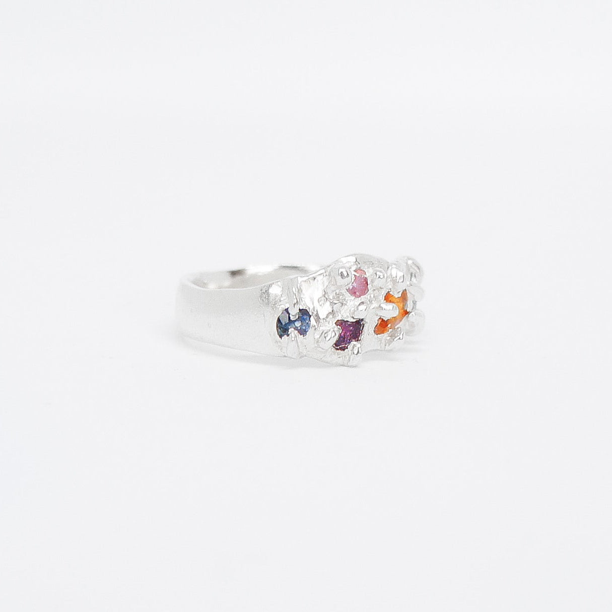 Silver ring with colorful stone on a white background