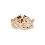 Gold mask-shaped ring on a white background