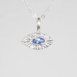 Silver pendant with a blue gemstone on a white background