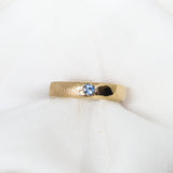 Gold ring with a blue gemstone on a white fabric background