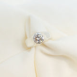 Close-up of a white fabric with a small diamond-like stone on a light background