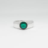 Silver ring with a green gemstone on a white background