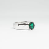 Silver ring with a green gemstone on a white background