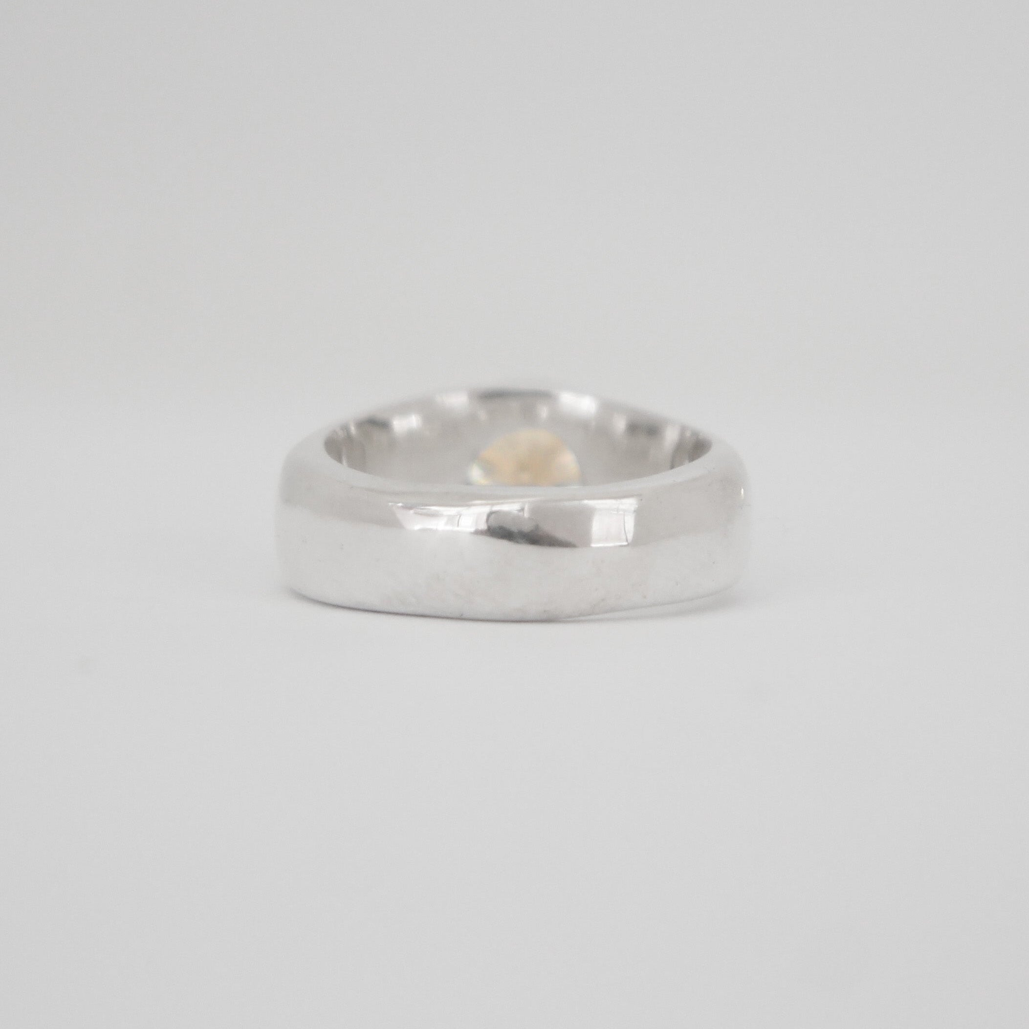 Silver ring on a light gray background