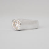 Silver ring with a diamond on a light gray background