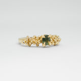 Gold ring with a green gemstone on a white background