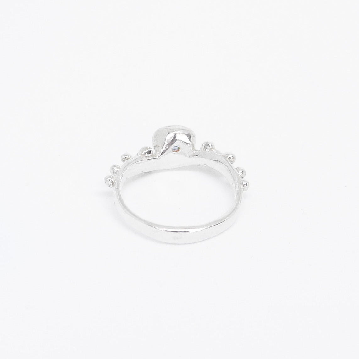 Silver ring with a small stone on a white background