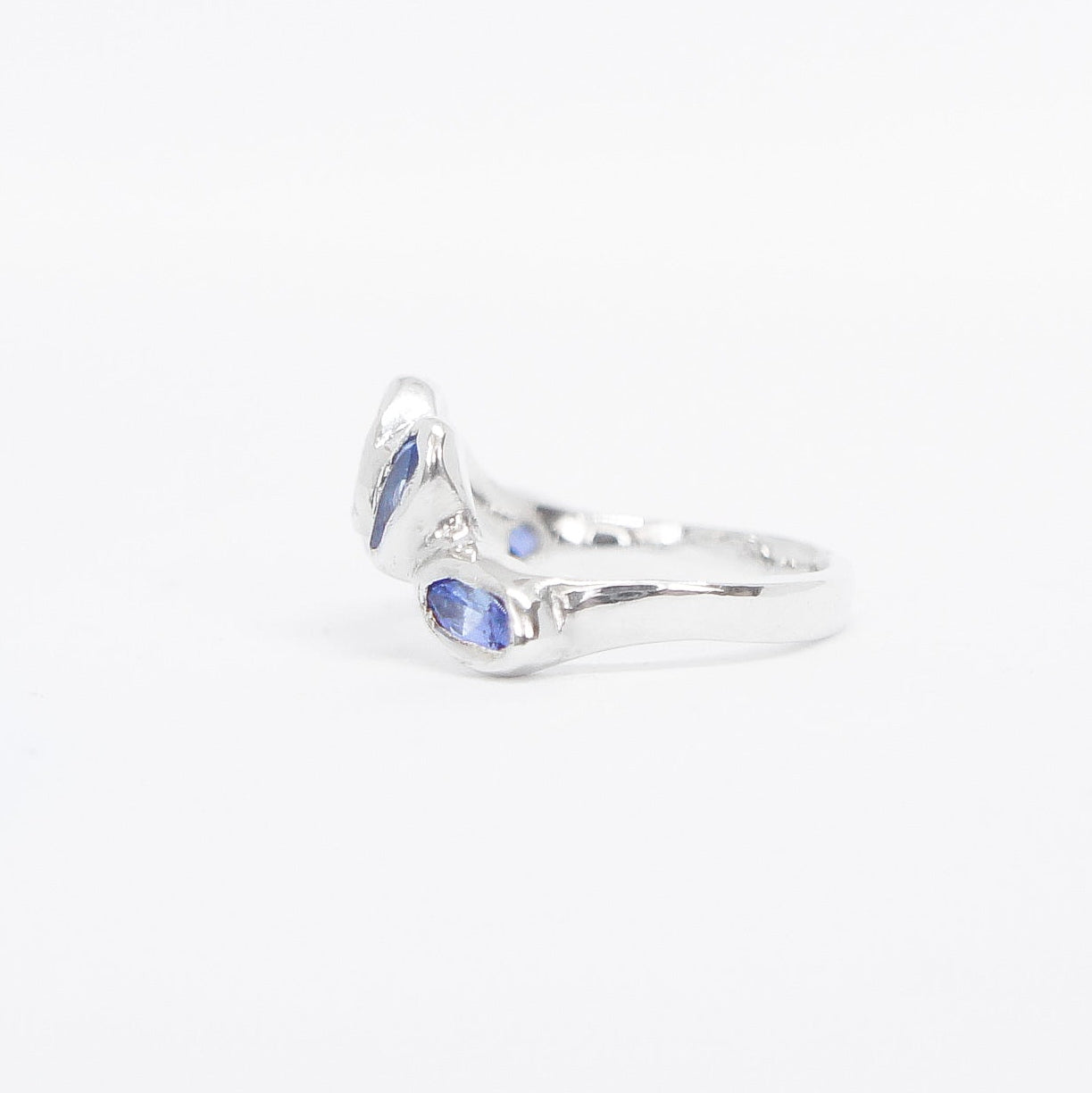 Silver ring with blue gemstones on a white background