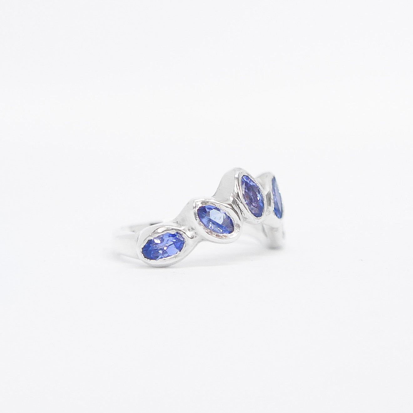 Silver ring with blue gemstones on a white background