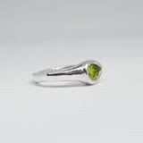 Silver ring with a green gemstone on a white background