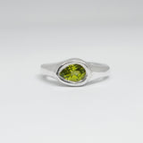 Silver ring with a green gemstone on a white background