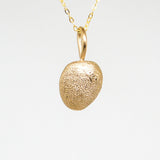 Gold pendant necklace on a light gray background