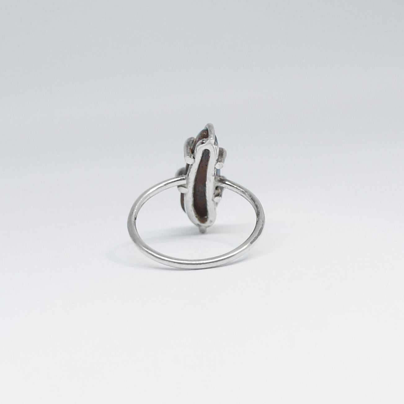 Silver ring with a dark solid opal on a light gray background