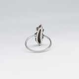 Silver ring with a dark solid opal on a light gray background