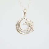 Silver necklace with a crescent moon pendant on a white background