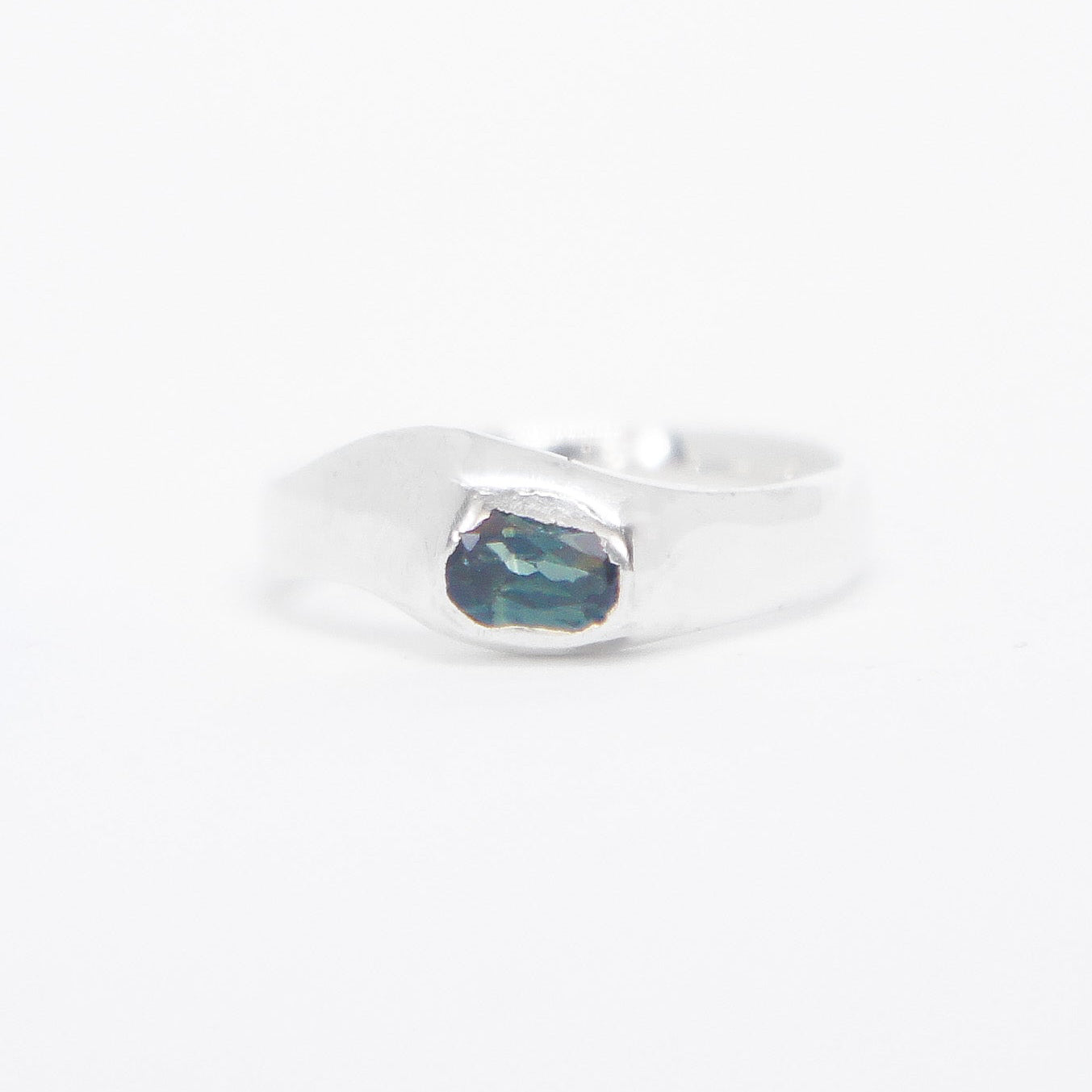 Silver ring with a blue stone on a white background