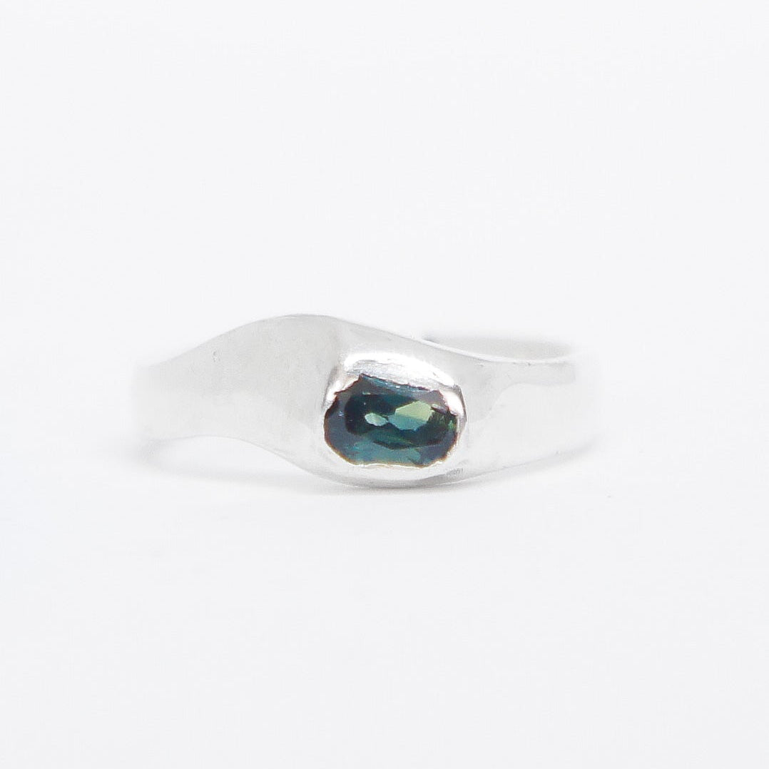 Silver ring with a green gemstone on a white background