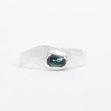 Silver ring with a green gemstone on a white background