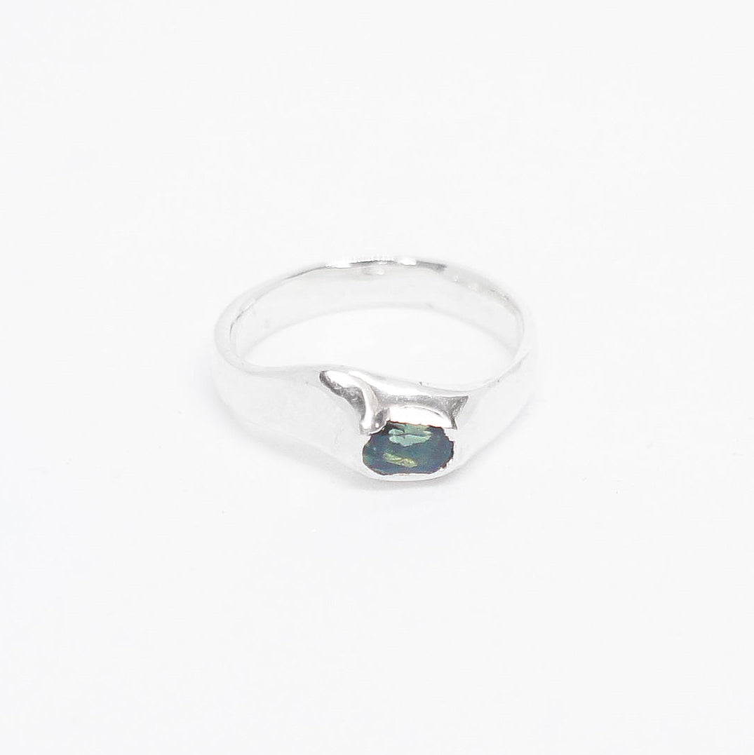 Silver ring with a green gemstone on a white background
