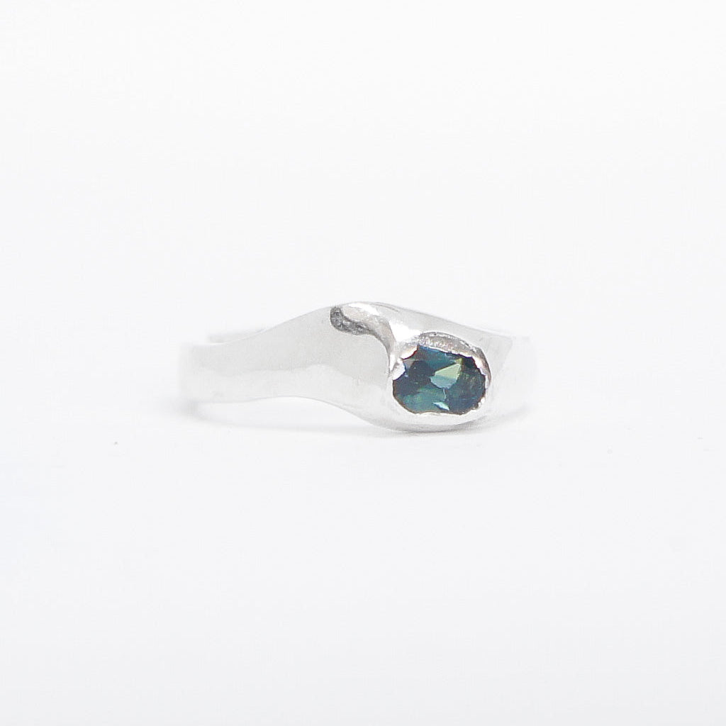 Silver earring with a blue gemstone on a white background