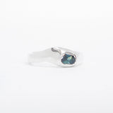 Silver earring with a blue gemstone on a white background