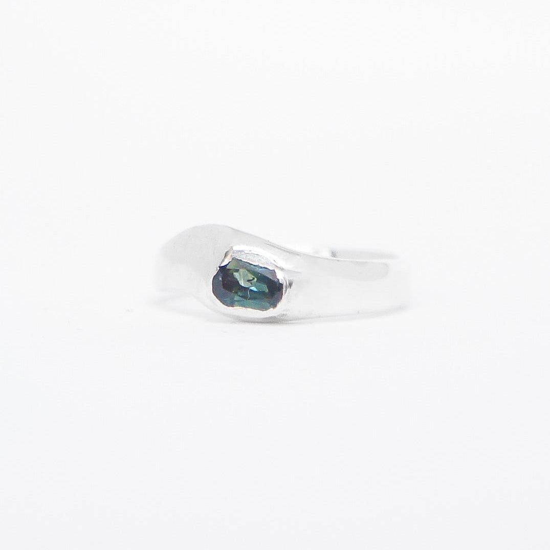 Silver ring with a blue gemstone on a white background