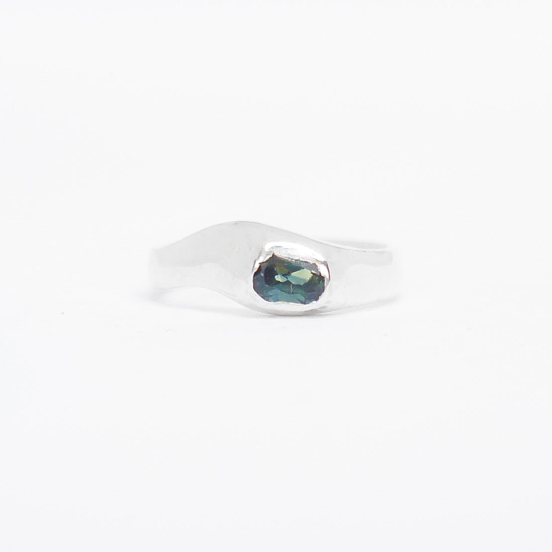 Silver ring with a green gemstone on a white background