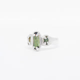 Silver ring with a green tourmaline gemstone on a white background