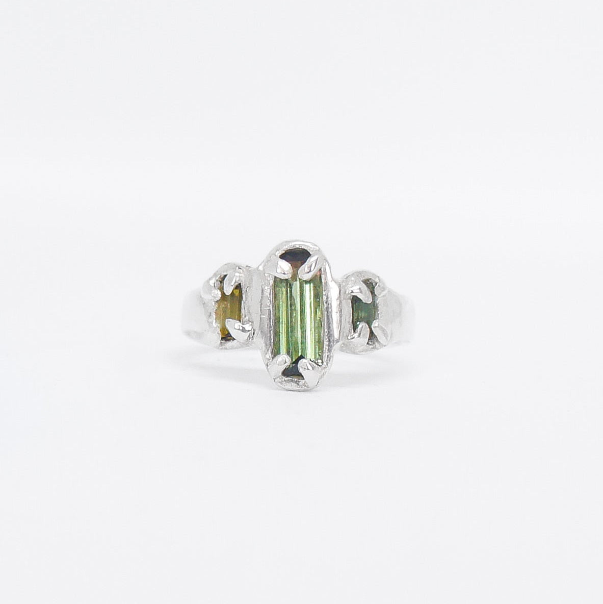 Silver ring with green gemstone on a white background
