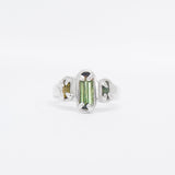 Silver ring with green gemstone on a white background