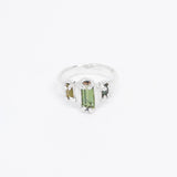 Silver ring with a green tourmaline gemstone on a white background