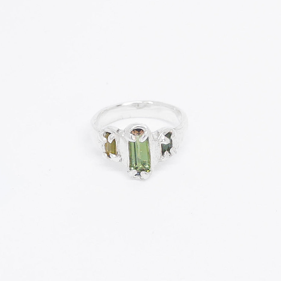 Silver ring with a green tourmaline gemstone on a white background