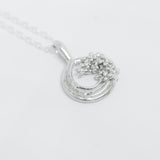 Silver necklace with a circular pendant on a white background