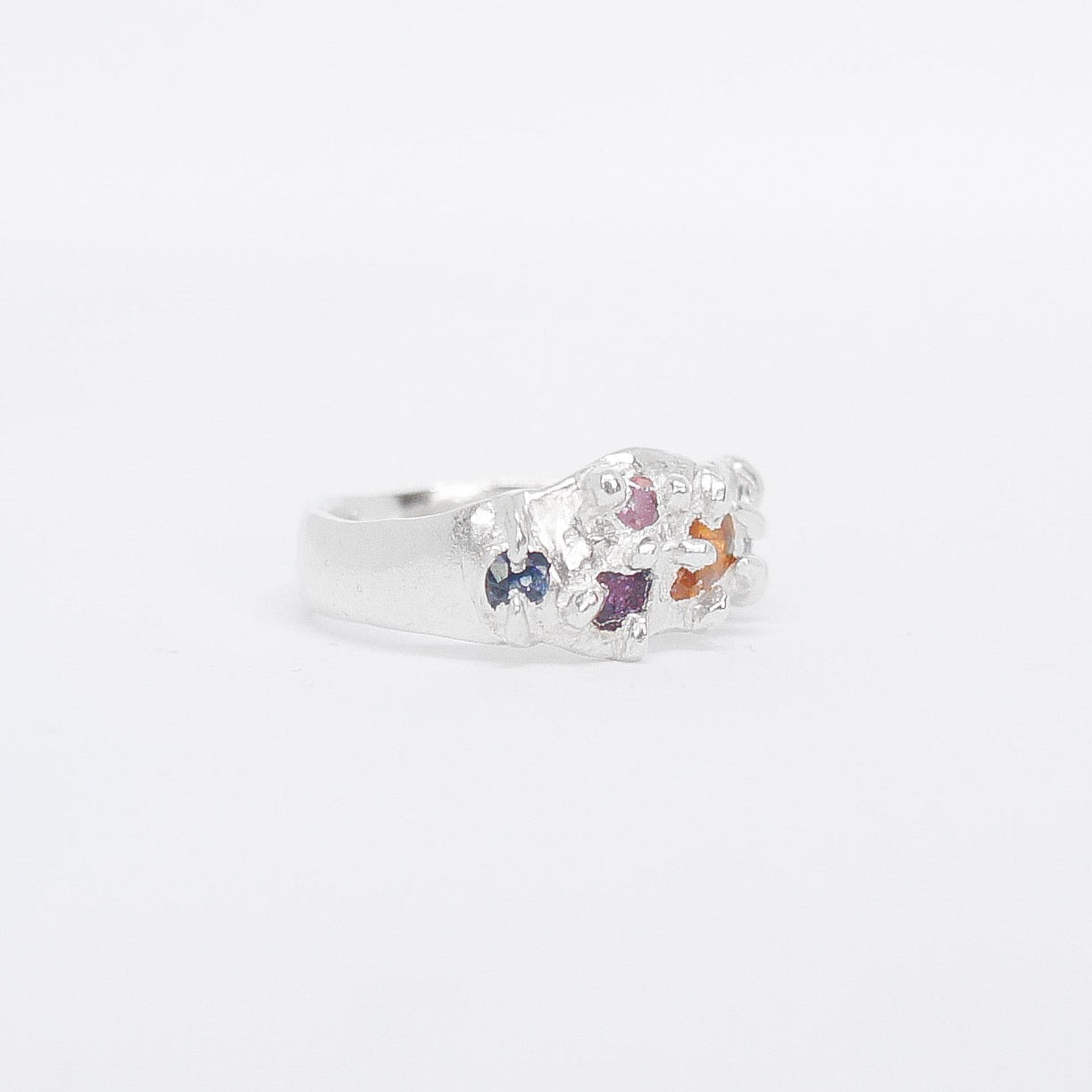 Silver ring with colourful stones charms on a white background
