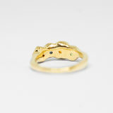 Gold ring with multi coloured gemstone on a light gray background
