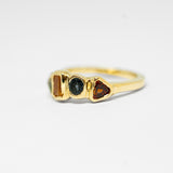 Gold ring with gemstones on a light gray background