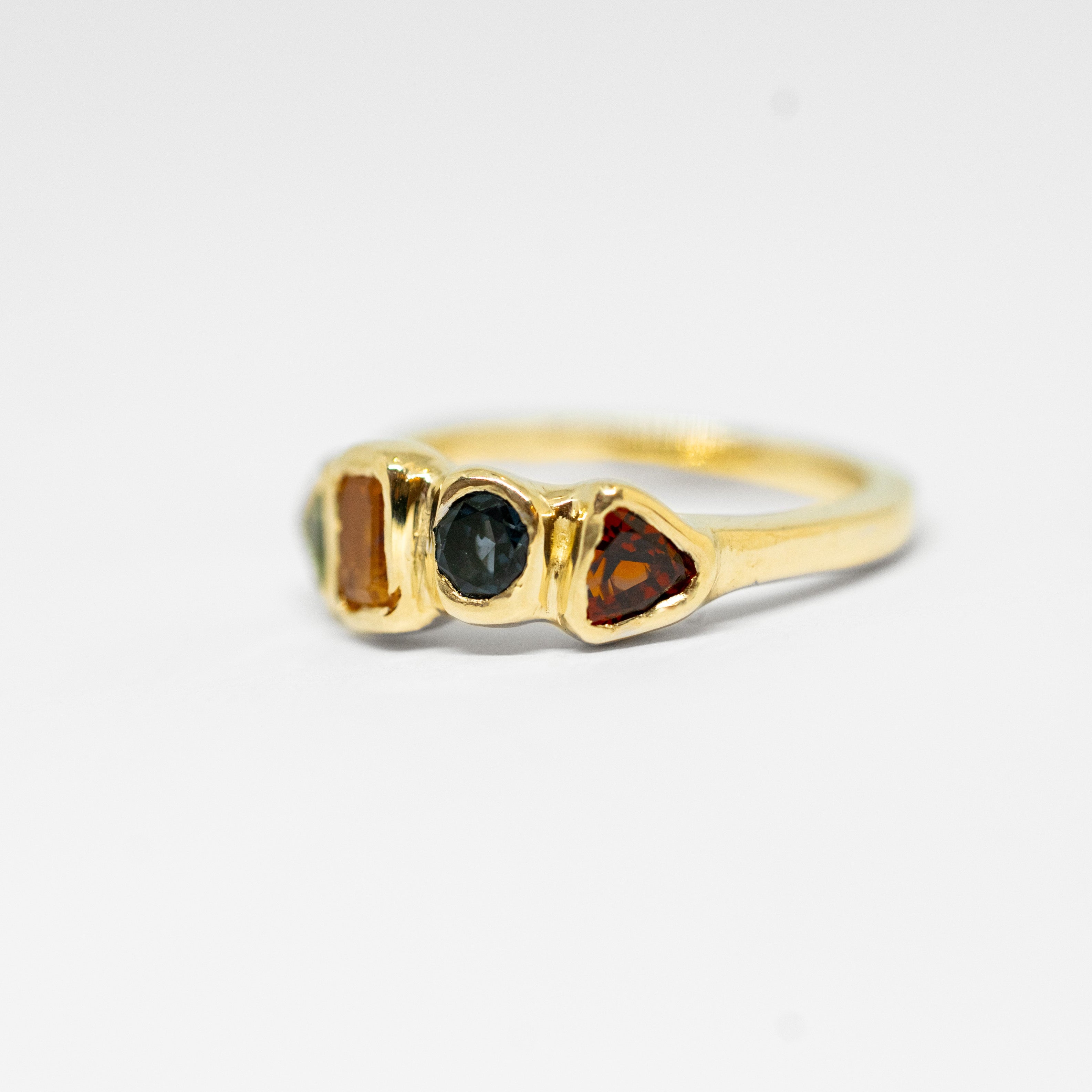 Gold ring with gemstones on a light gray background