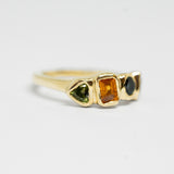 Gold ring with multicolored gemstones on a white background