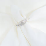 Close-up of a white dress with a decorative belt on a light background