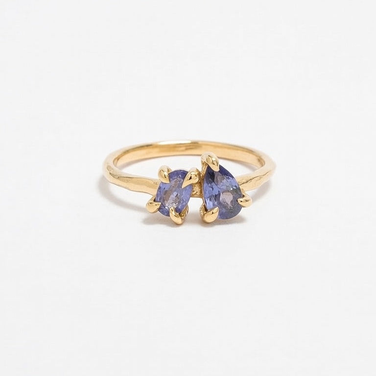 Gold ring with blue gemstones on a white background