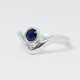 Silver ring with a blue gemstone on a white background