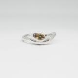 Silver ring with a green gemstone on a white background