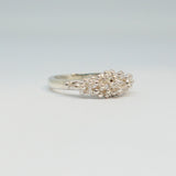 Silver ring with floral design on a light gray background