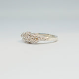 Silver ring with a textured design on a light gray background