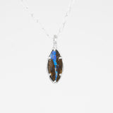 Necklace with a pendant featuring blue and brown stones on a white background