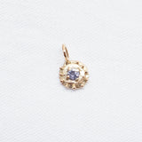 Gold pendant with a blue gemstone on a white background